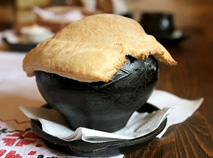 Borshch pa-tserakhouski, a red-beet soup served in a cast-iron pot covered with a pancake
